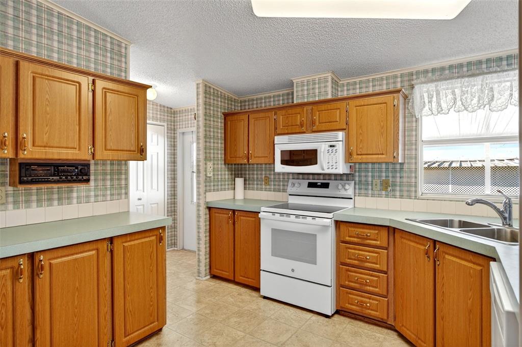 8046 Highpoint Boulevard Brooksville, FL 34613 - Photo 11 of 47 a kitchen with stainless steel appliances granite countertop a sink and a stove