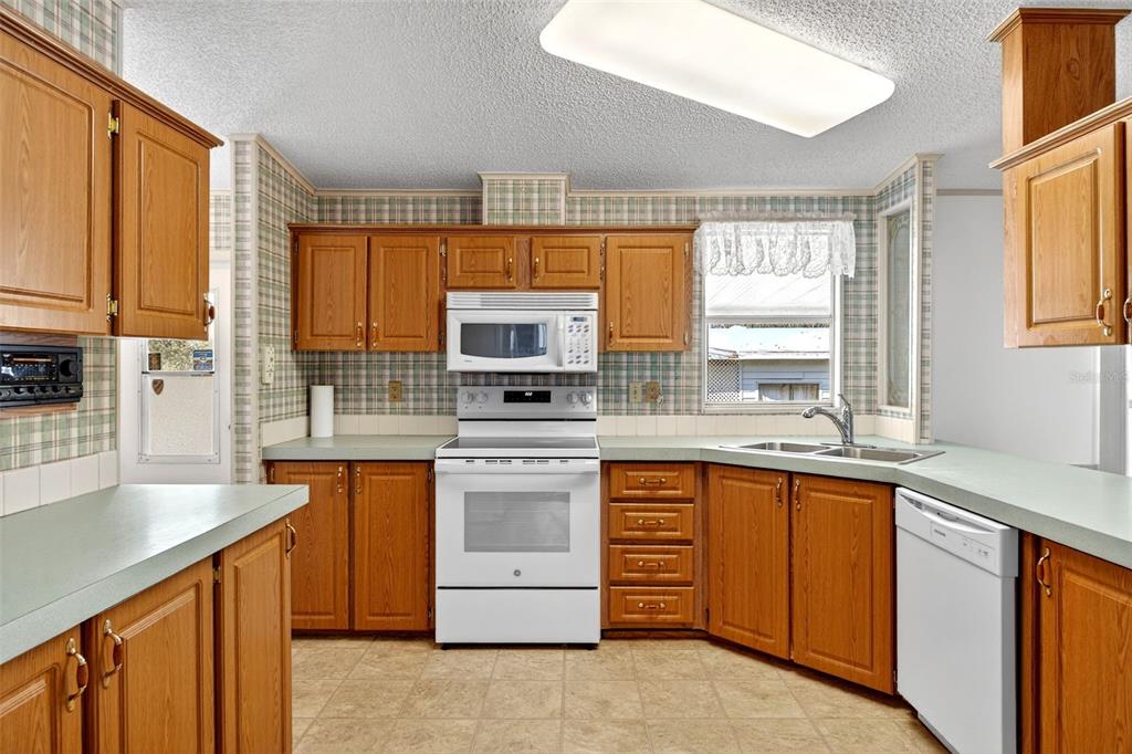 8046 Highpoint Boulevard Brooksville, FL 34613 - Photo 13 of 47 a kitchen with stainless steel appliances granite countertop a stove sink and cabinets