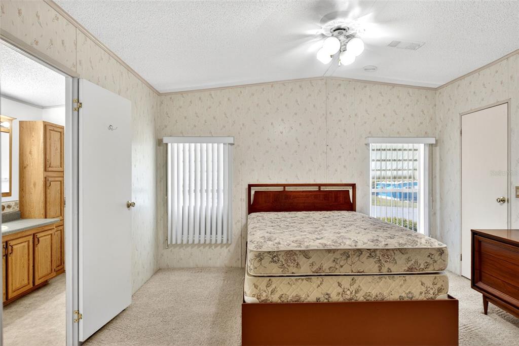 8046 Highpoint Boulevard Brooksville, FL 34613 - Photo 15 of 47 a bedroom with a large bed and a chandelier
