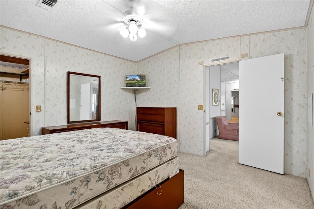 8046 Highpoint Boulevard Brooksville, FL 34613 - Photo 16 of 47 a bedroom with a bed and a chandelier