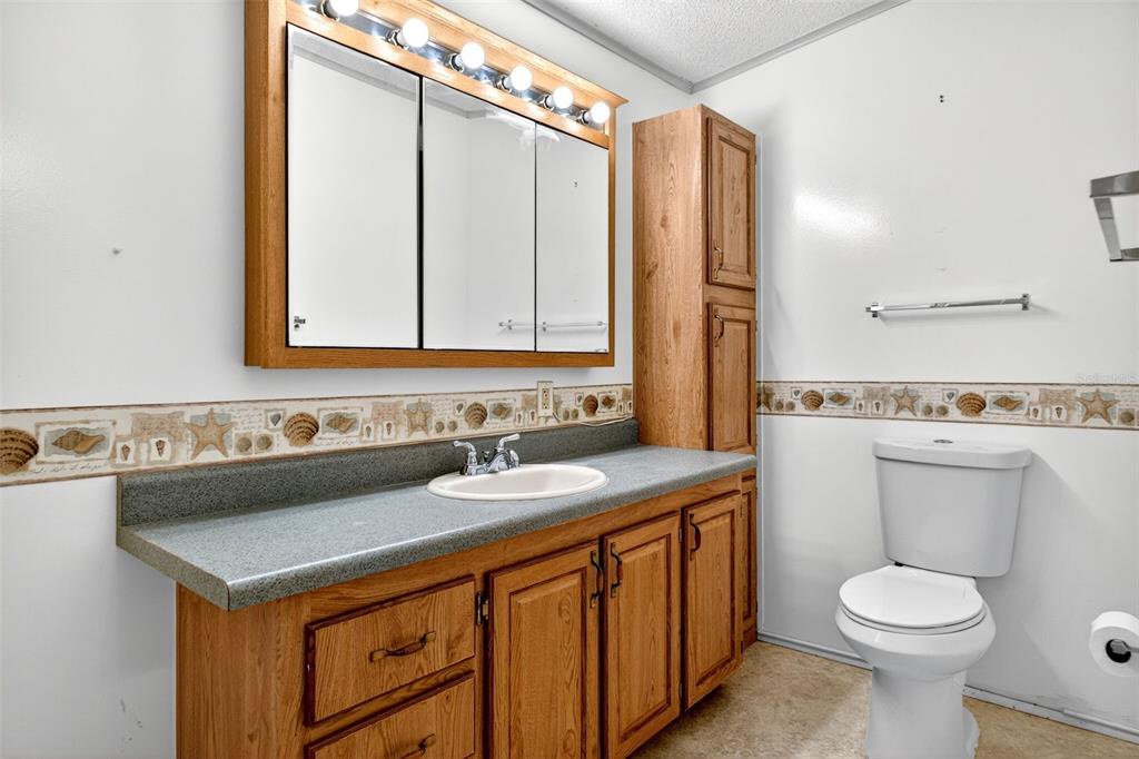 8046 Highpoint Boulevard Brooksville, FL 34613 - Photo 18 of 47 a bathroom with a sink a toilet and mirror