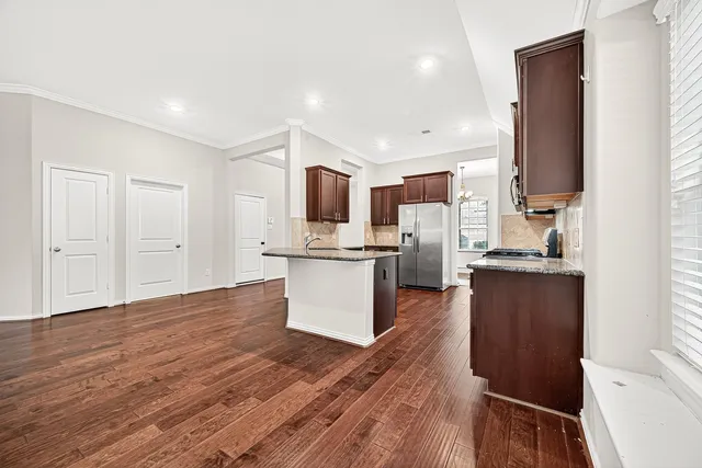 a kitchen with a refrigerator and a stove top oven