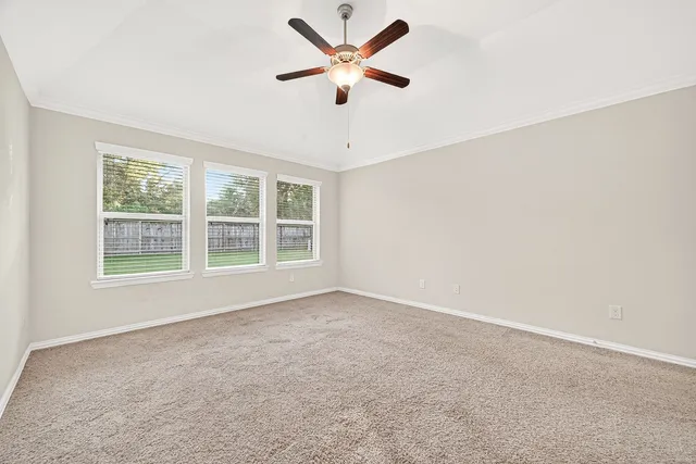 an empty room with fan and windows