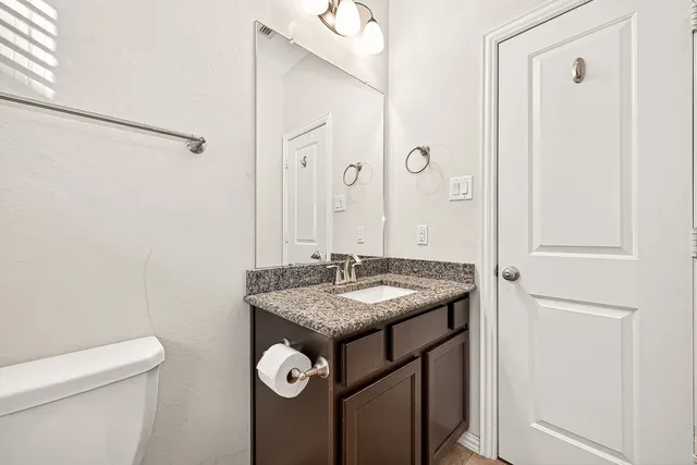 a bathroom with a granite countertop sink and a mirror
