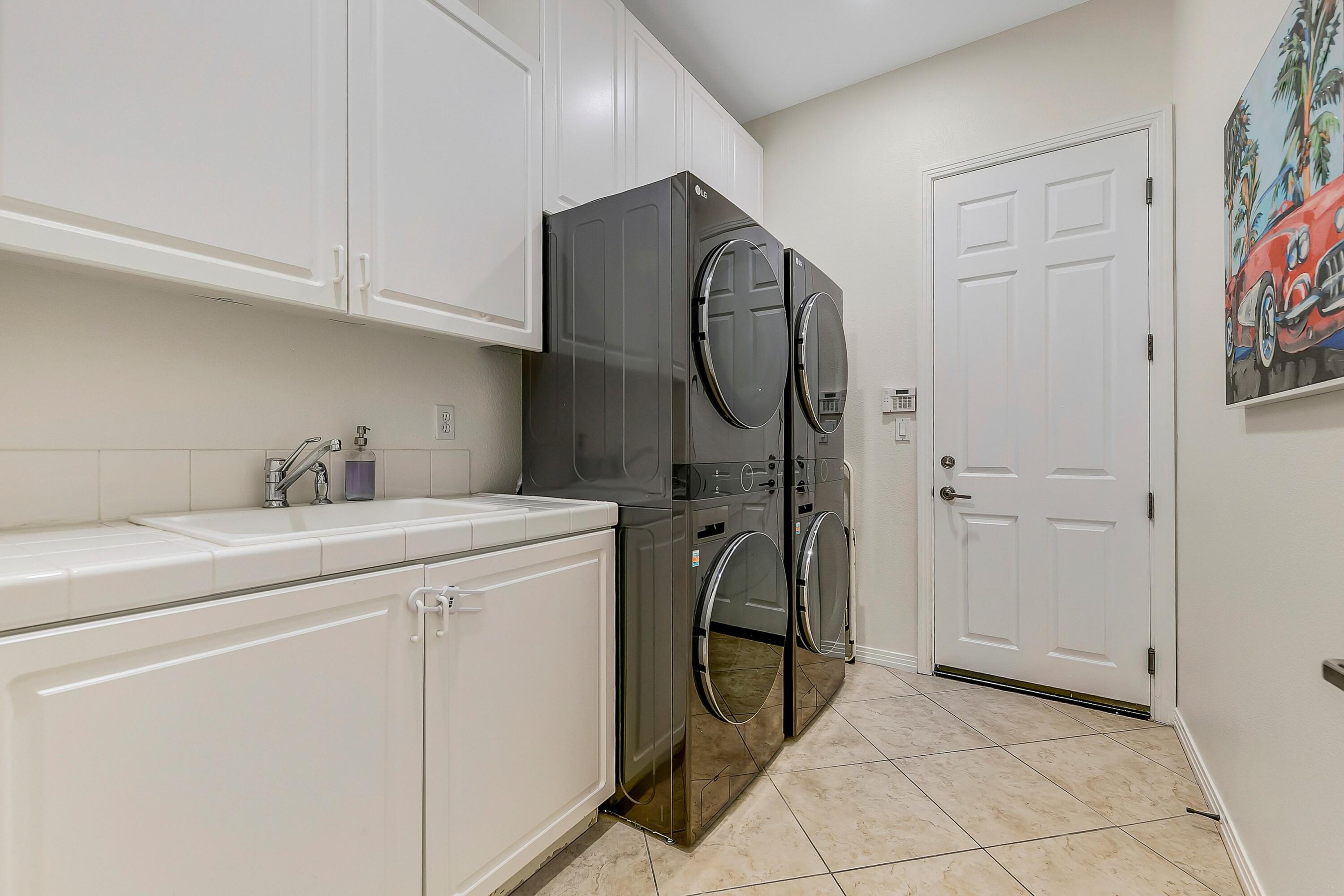 48678 Cascade Street Indio, CA 92201 - Photo 39 of 78 a utility room with cabinets washer and dryer