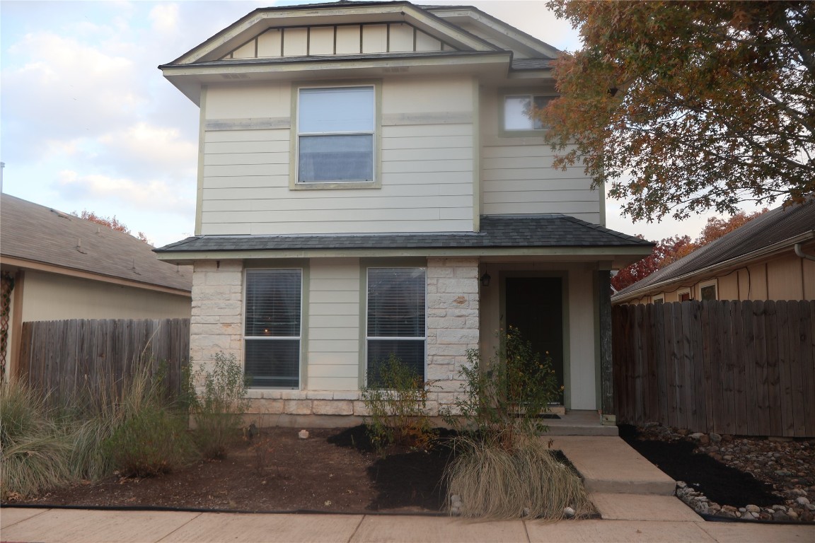 View of front facade with stone siding and roof with shingles