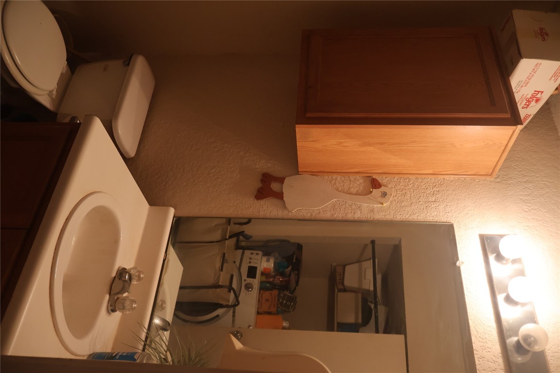 4523 Secure Lane Austin, TX 78725 - Photo 3 of 10 Bathroom featuring a textured wall and vanity