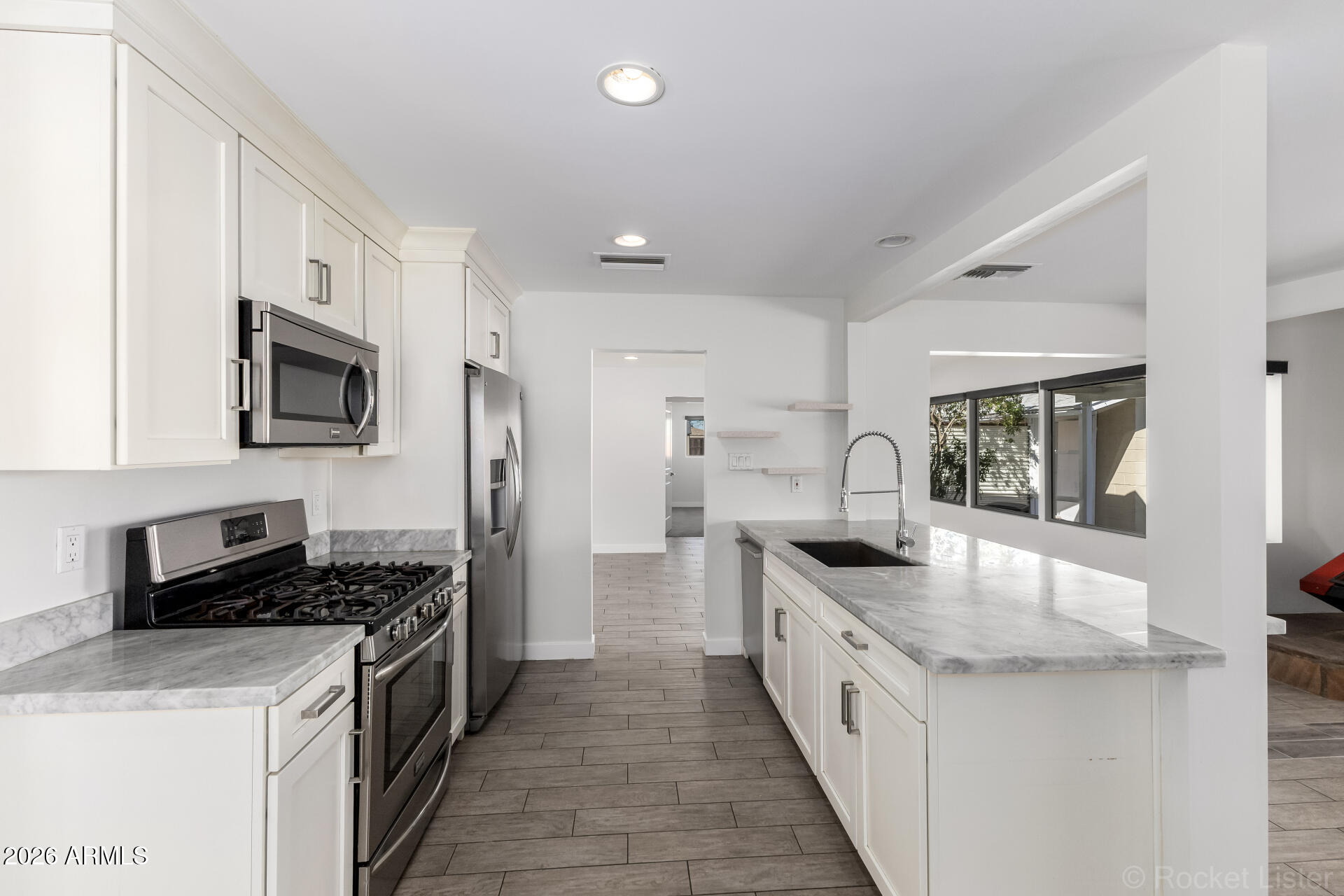 3930 East Oak Street Phoenix, AZ 85008 - Photo 10 of 61 a large kitchen with stainless steel appliances granite countertop a stove a sink and a refrigerator