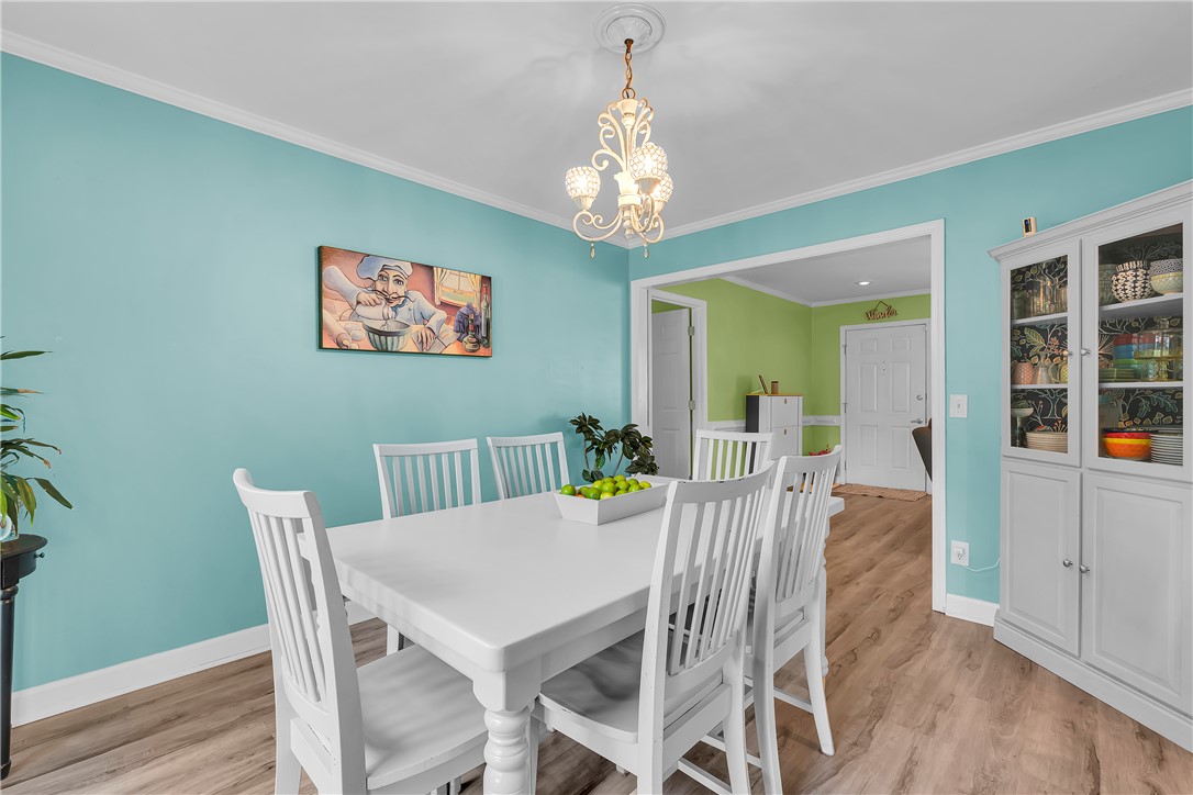 1305 Hanover Road Anderson, SC 29621 - Photo 6 of 29 An elegant chandelier hangs above the dining space, highlighting rich wood floors and crown molding.