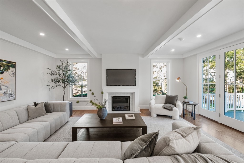 201 Lowell Road Wellesley, MA 02481 - Photo 3 of 41 a living room with furniture a flat screen tv and a fireplace