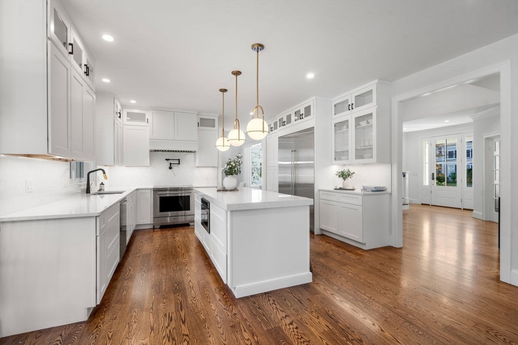 201 Lowell Road Wellesley, MA 02481 - Photo 10 of 42 a large kitchen with stainless steel appliances kitchen island a large counter top and a wooden floors