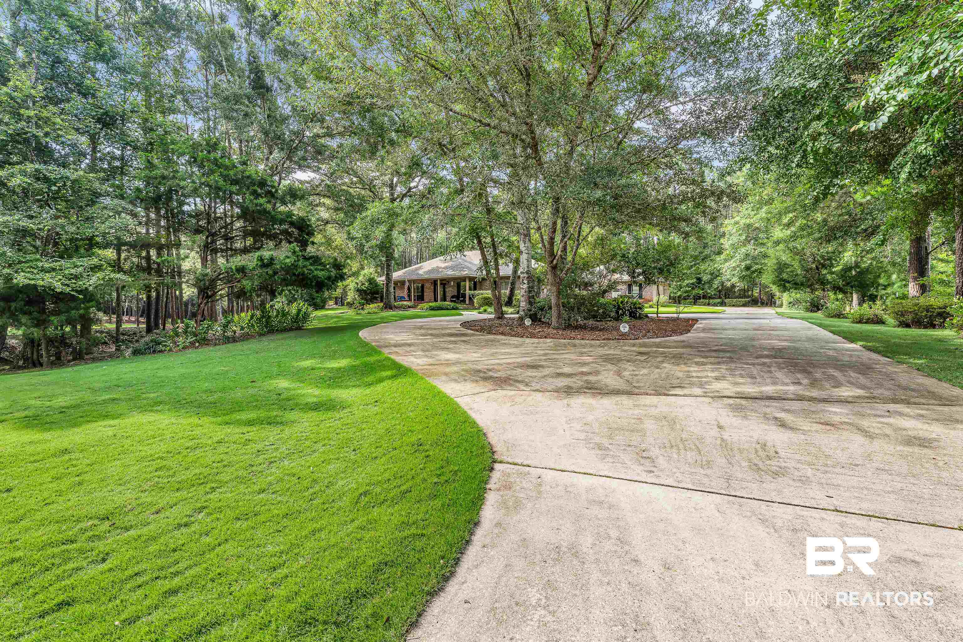 7014 Blakeley Road Daphne, AL 36527 - Photo 3 of 45 Expansive concrete driveway with a central circular island, framed by mature trees and lush green lawns