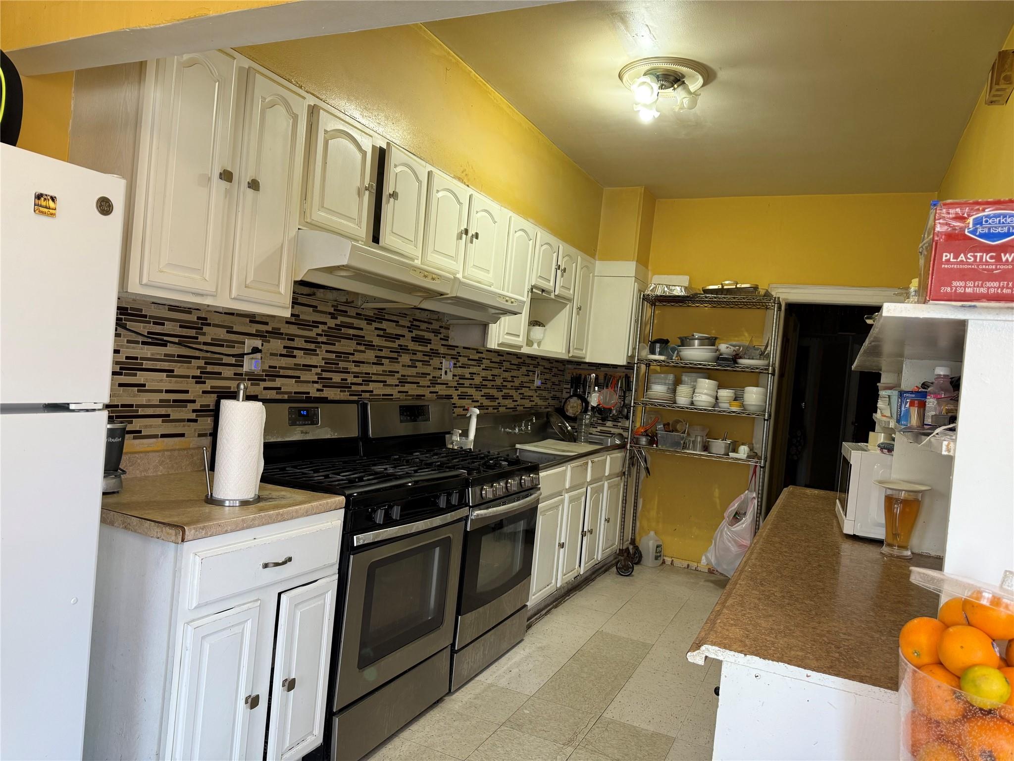 35-46 92nd Street Queens, NY 11372 - Photo 2 of 10 a kitchen with stainless steel appliances granite countertop a stove and a refrigerator