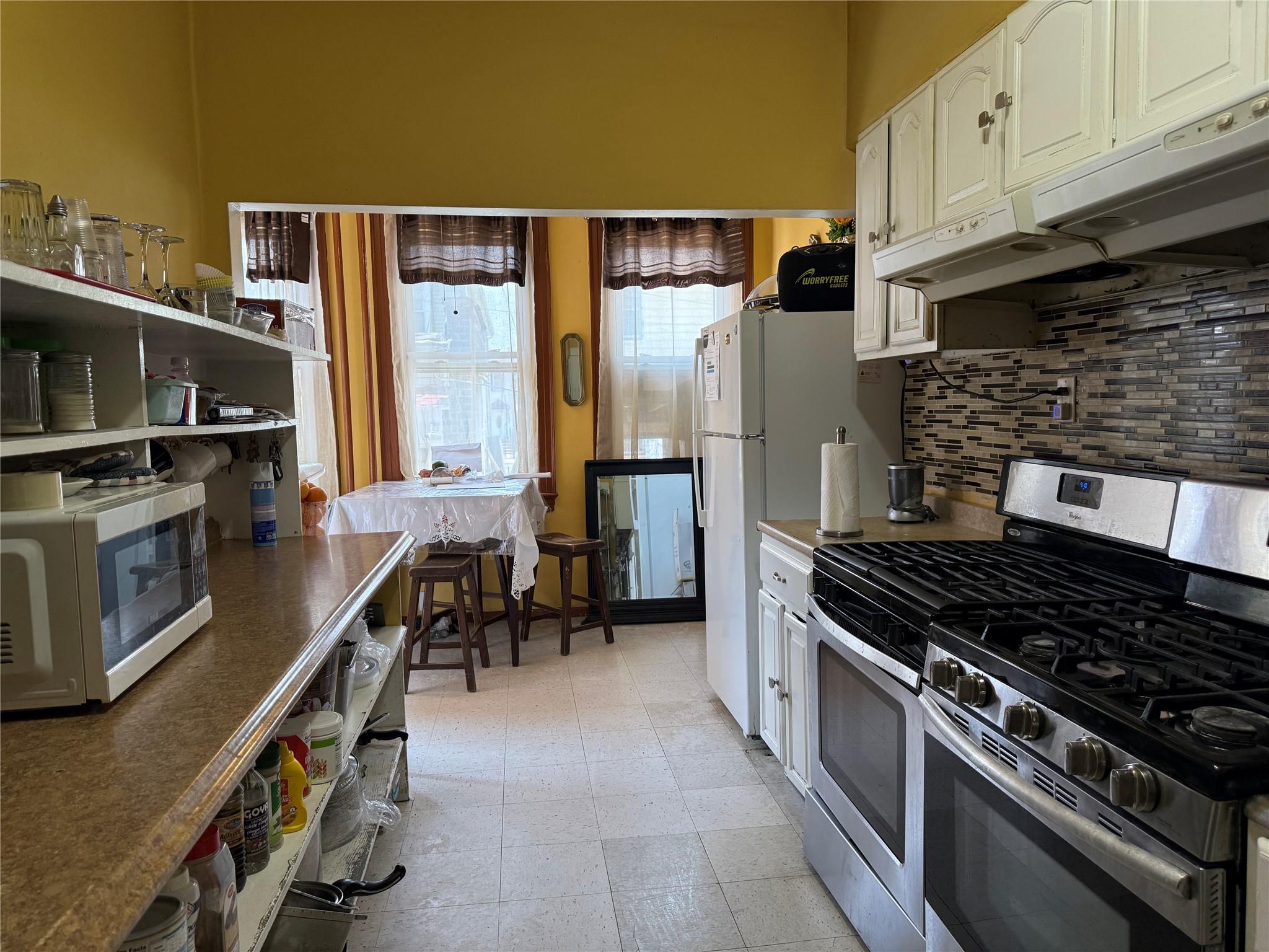 35-46 92nd Street Queens, NY 11372 - Photo 3 of 10 a kitchen with granite countertop a stove and a refrigerator