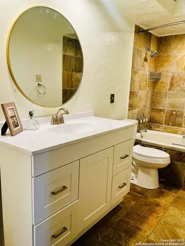 a spacious bathroom with a sink mirror and toilet