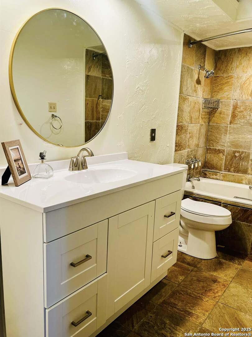 8655 Datapoint, Unit 404 San Antonio, TX 78229 - Photo 11 of 25 a spacious bathroom with a sink mirror and toilet