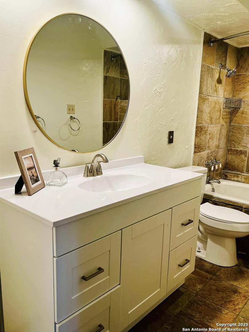 8655 Datapoint, Unit 404 San Antonio, TX 78229 - Photo 13 of 25 a bathroom with a sink mirror vanity and toilet