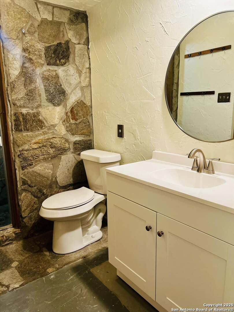 8655 Datapoint, Unit 404 San Antonio, TX 78229 - Photo 17 of 25 a bathroom with a toilet sink and mirror