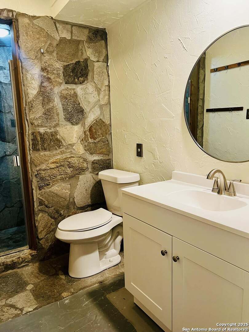 8655 Datapoint, Unit 404 San Antonio, TX 78229 - Photo 22 of 25 a bathroom with a toilet sink and mirror