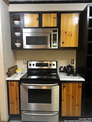 a kitchen with stainless steel appliances granite countertop a stove and a microwave