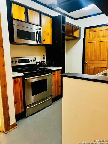 a kitchen with stainless steel appliances a stove a microwave and a refrigerator