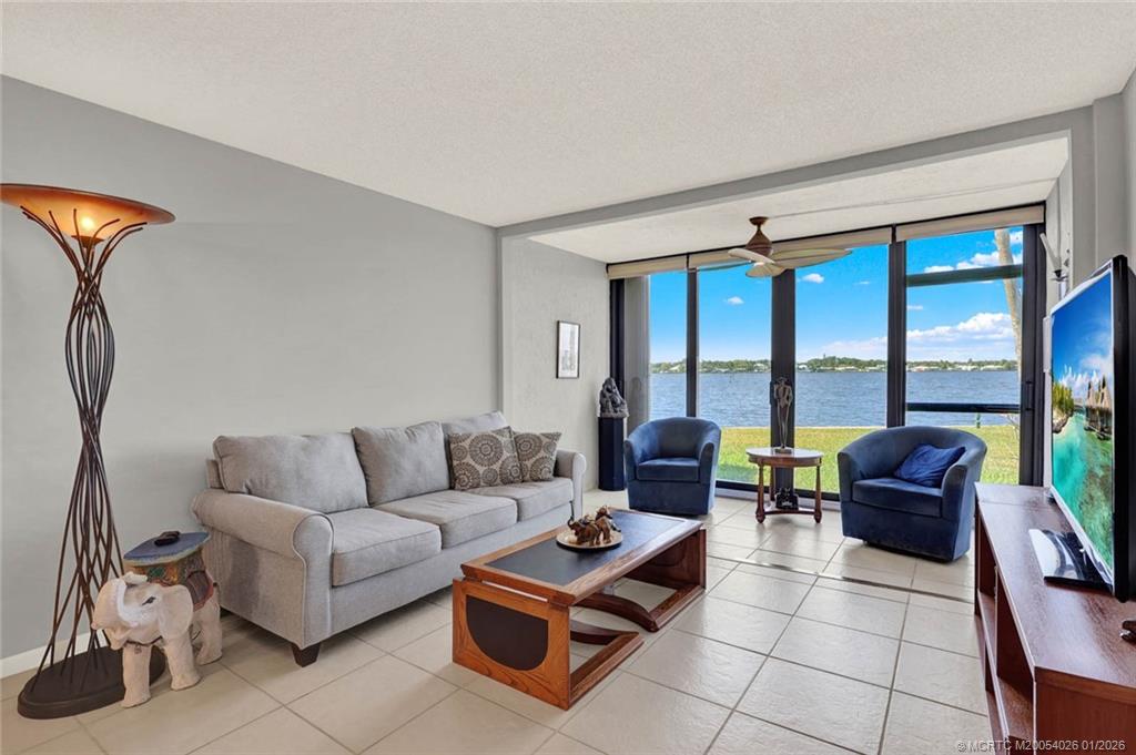 1950 Southwest Palm City Road, Unit 8106 Stuart, FL 34994 - Photo 22 of 54 a living room with furniture and a floor to ceiling window