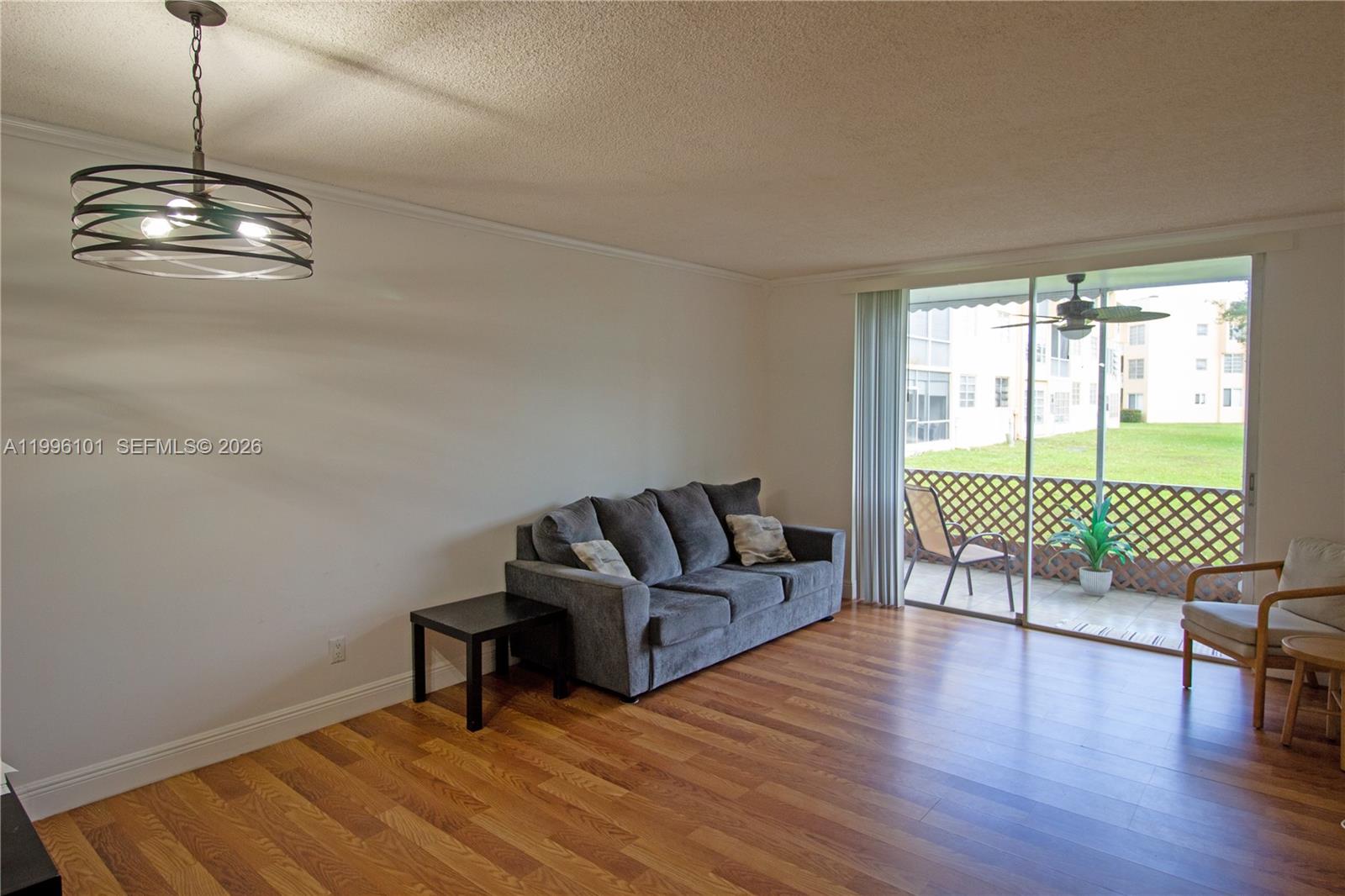 6020 Northwest 64th Avenue, Unit 108 Tamarac, FL 33319 - Photo 13 of 19 a living room with furniture and a floor to ceiling window