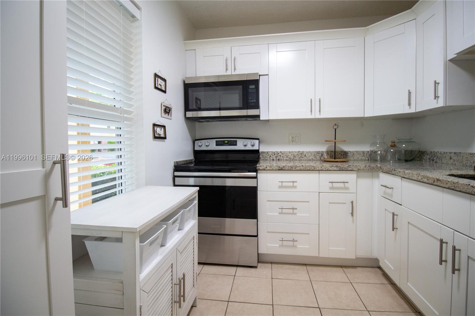 6020 Northwest 64th Avenue, Unit 108 Tamarac, FL 33319 - Photo 7 of 19 a kitchen with cabinets appliances and a window