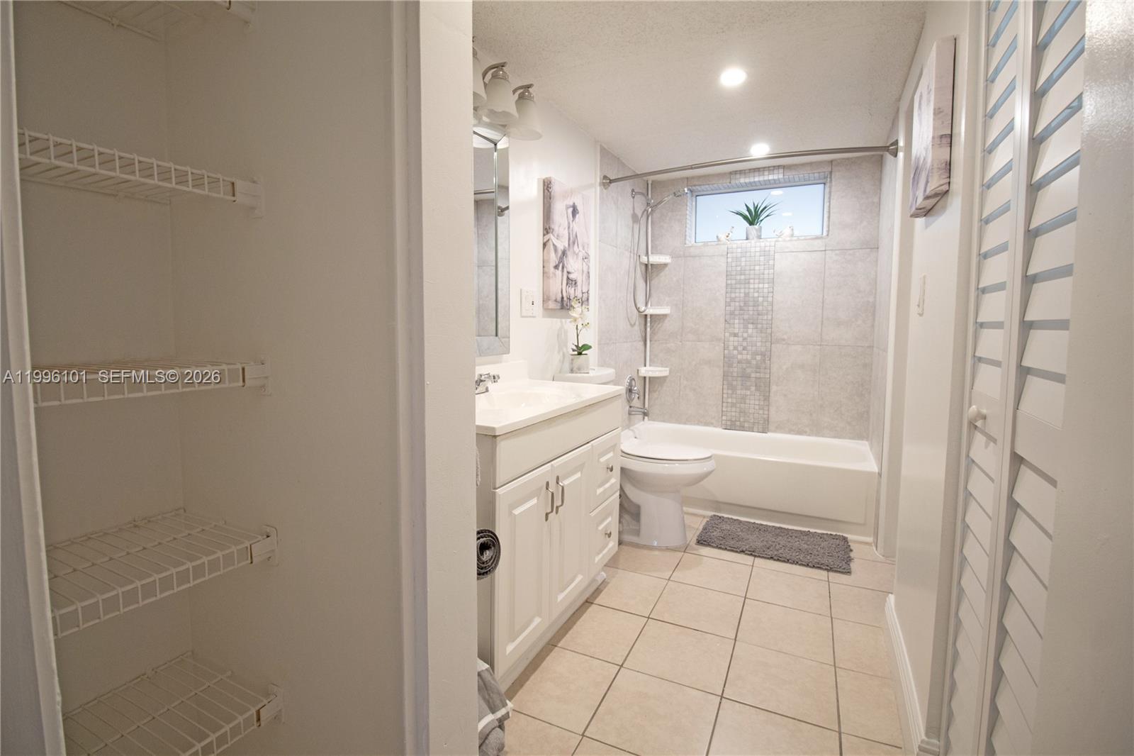 6020 Northwest 64th Avenue, Unit 108 Tamarac, FL 33319 - Photo 10 of 19 a bathroom with a granite countertop sink a toilet and shower