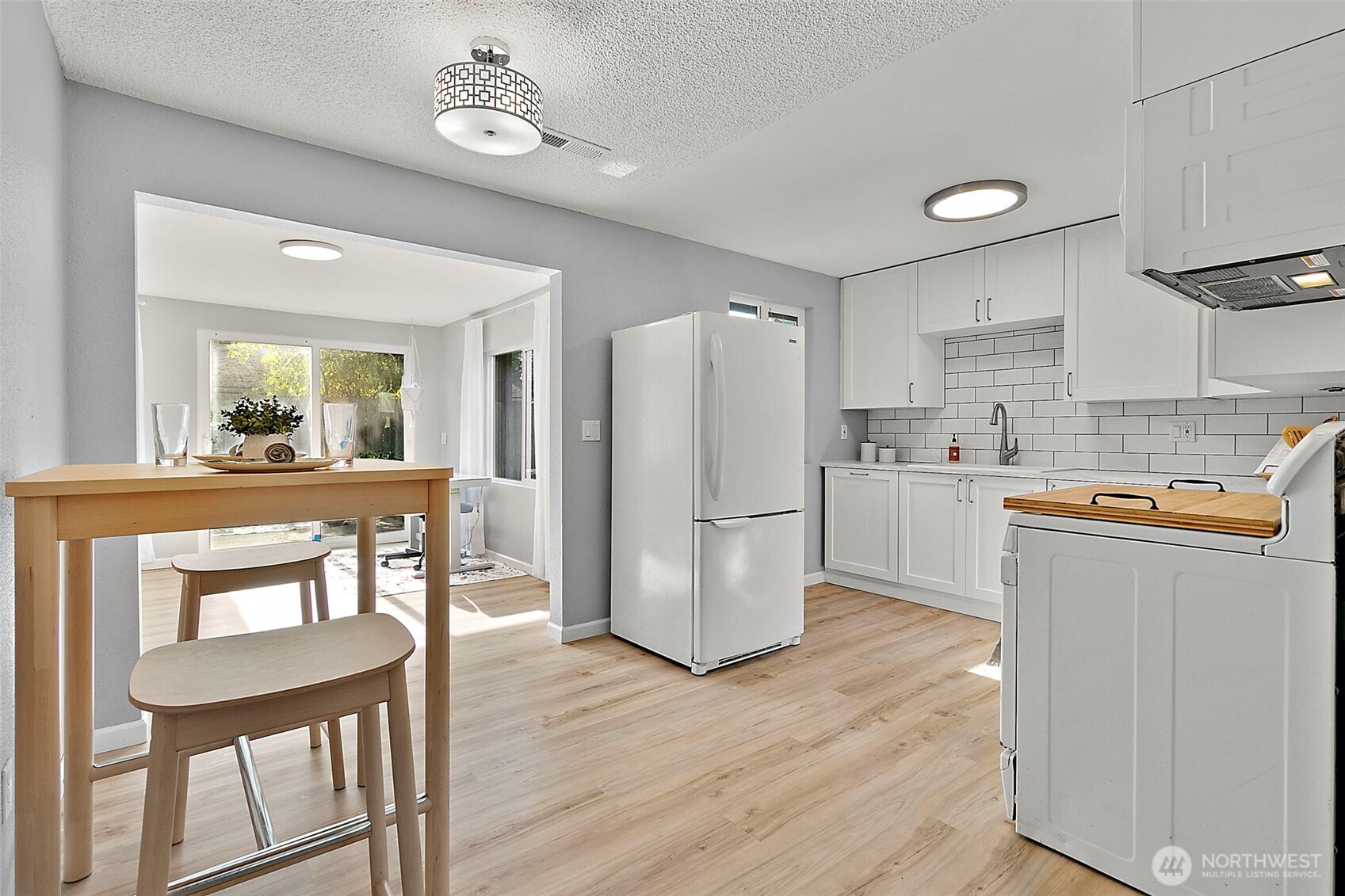 26104 195th Place Southeast Covington, WA 98042 - Photo 8 of 29 a kitchen with a refrigerator a dining table and chairs