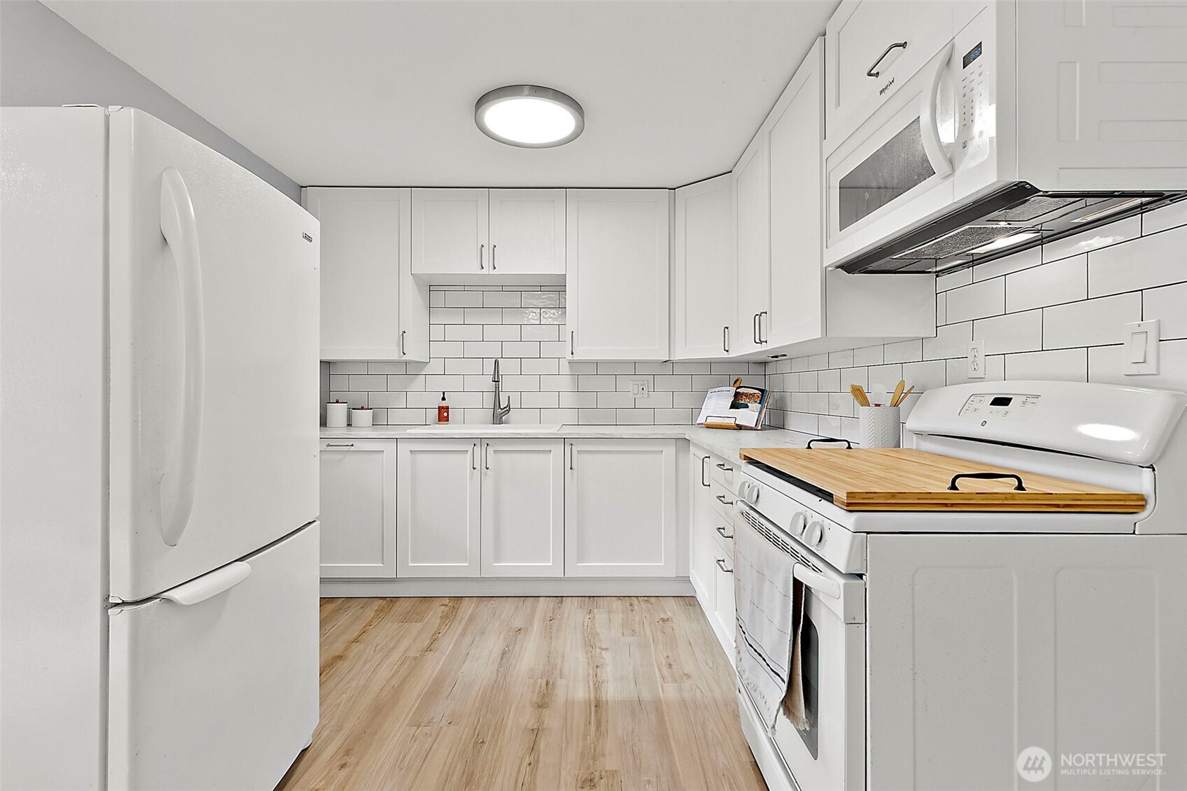 26104 195th Place Southeast Covington, WA 98042 - Photo 9 of 29 a kitchen with stainless steel appliances a refrigerator a sink and white cabinets
