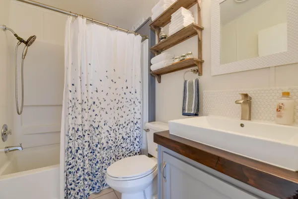 a bathroom with a sink a toilet and shower