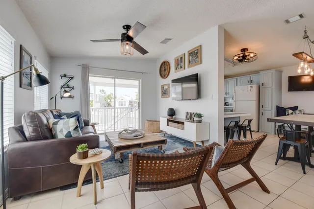 a living room with furniture a flat screen tv and a window