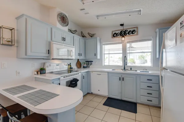 a kitchen with granite countertop a sink window and cabinets