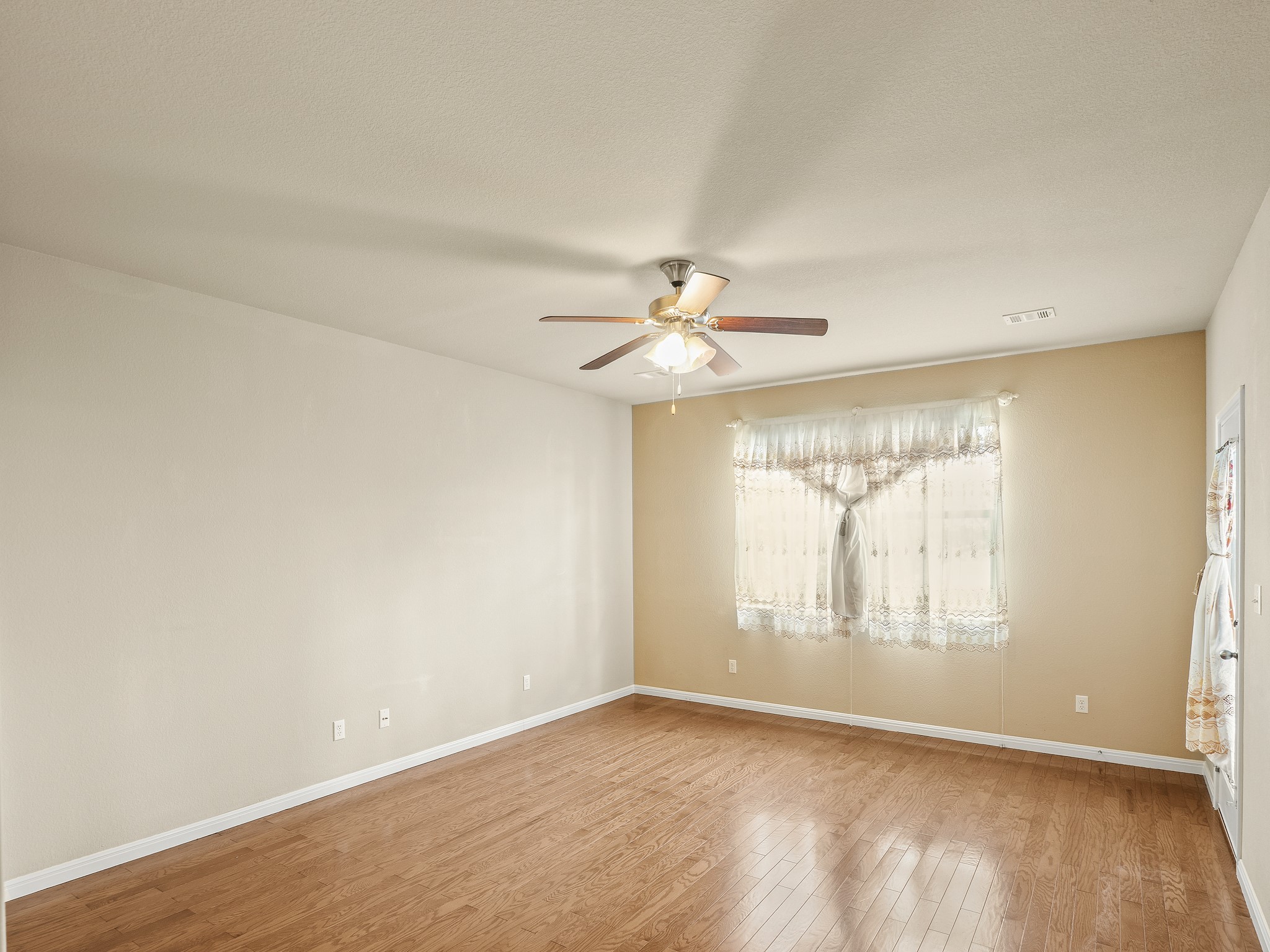 17805 Silent Harbor Loop Pflugerville, TX 78660 - Photo 27 of 34 an empty room with wooden floor fan and windows