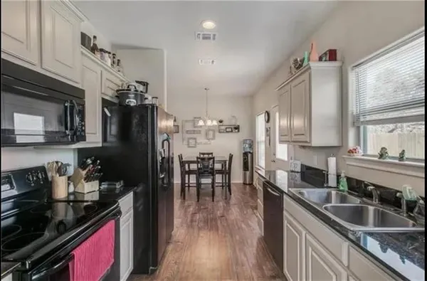 a kitchen with granite countertop a sink stove and cabinets