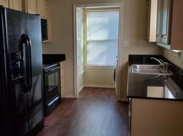 a kitchen with a refrigerator and a stove top oven