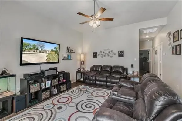 a living room with furniture a flat screen tv and a wall painting