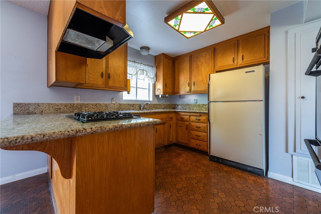 5171 Merrill Avenue Riverside, CA 92504 - Photo 14 of 34 a kitchen with granite countertop stainless steel appliances a refrigerator a sink and a stove