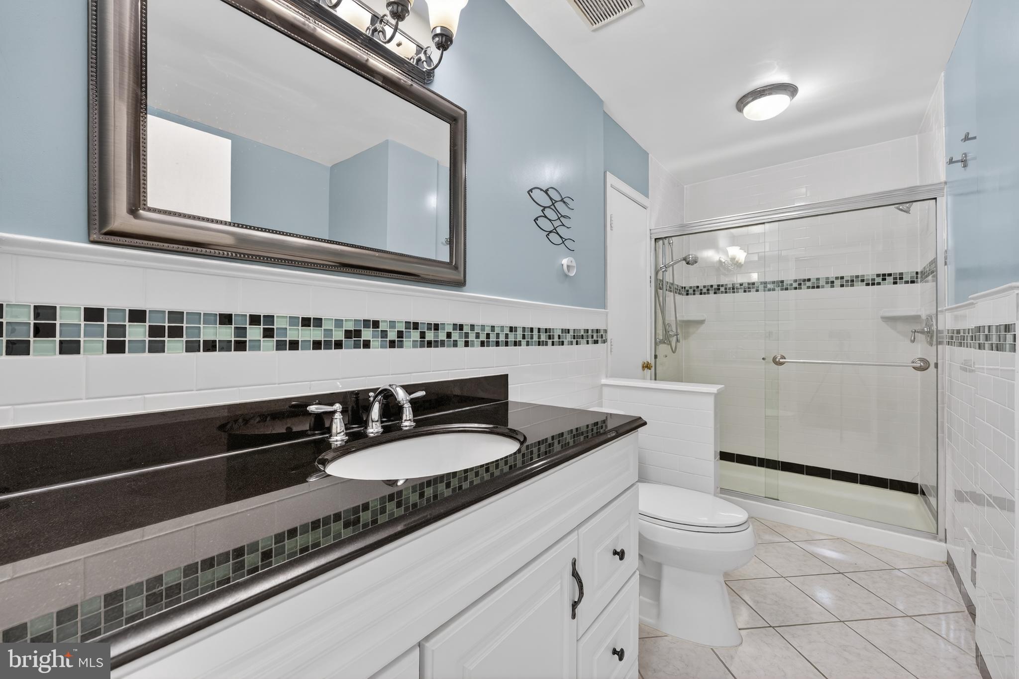 8139 Carrleigh Parkway Springfield, VA 22152 - Photo 18 of 27 a bathroom with a granite countertop sink and a toilet
