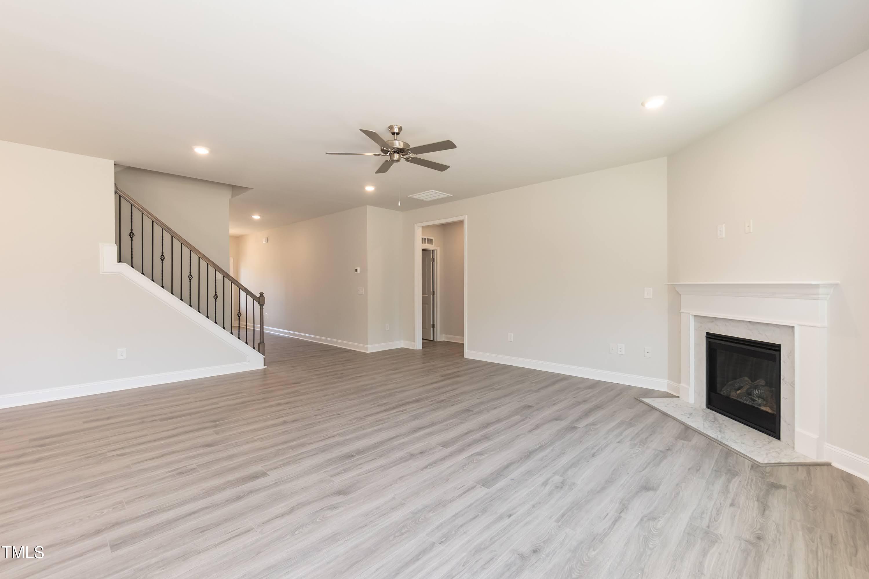 56 Braddock Court Garner, NC 27529 - Photo 16 of 55 a view of an empty room with wooden floor and a fireplace