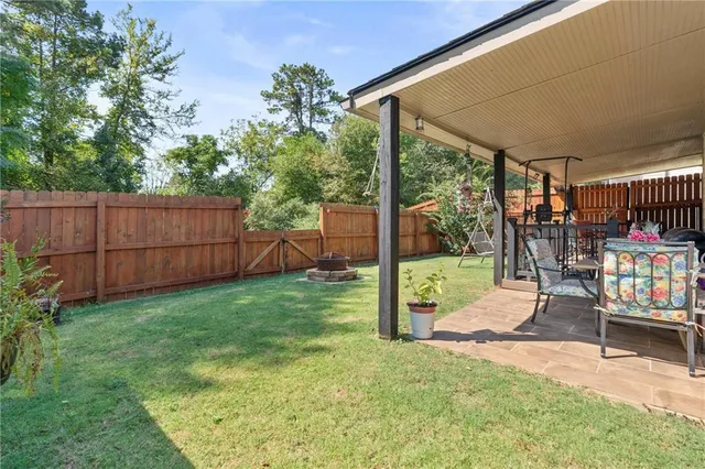 a view of a backyard with couches with wooden floor and fence