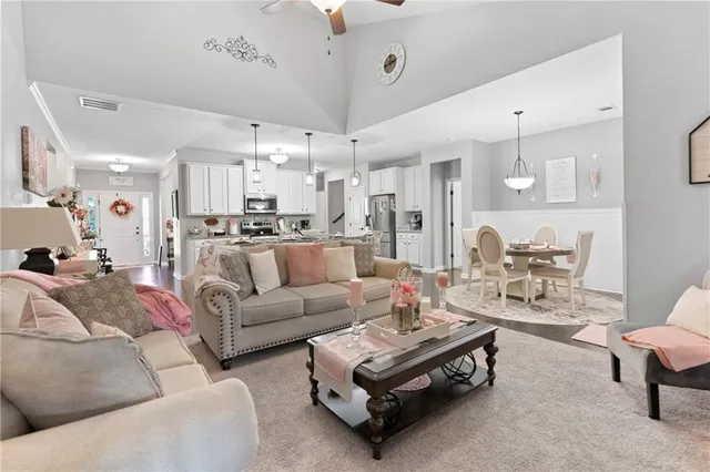 a living room with furniture kitchen view and a chandelier