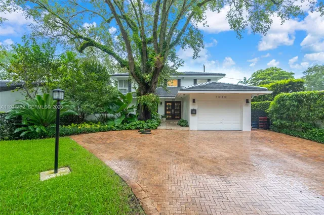 a front view of a house with a yard and garage