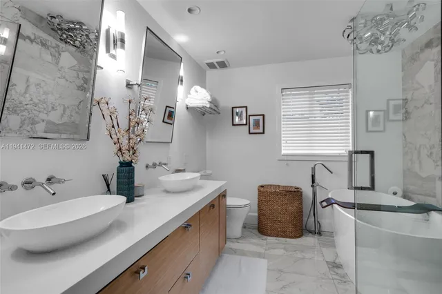 a bathroom with a double vanity sink bathtub and a mirror