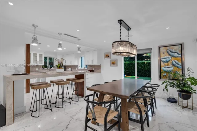 a kitchen with a dining table chairs stainless steel appliances and cabinets