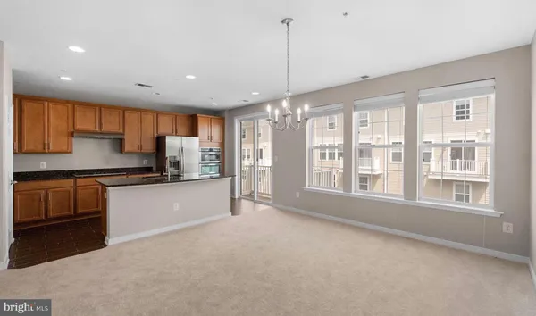 a large kitchen with stainless steel appliances kitchen island granite countertop a refrigerator and a stove top oven