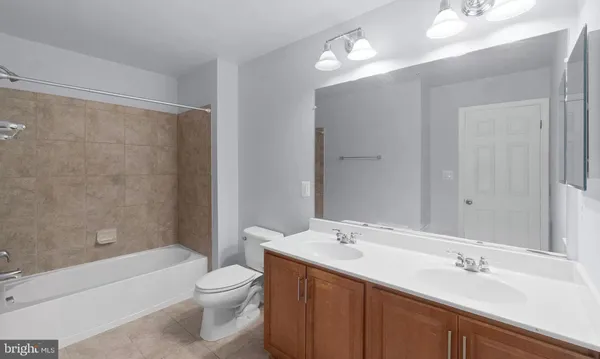 a bathroom with a double vanity sink toilet mirror and bathtub