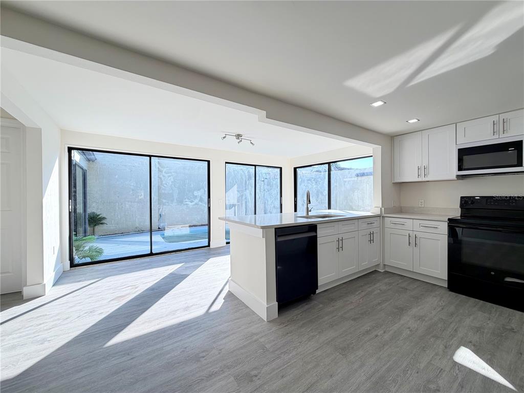 7314 Patio Row Hudson, FL 34667 - Photo 5 of 17 a large white kitchen with a large window and stainless steel appliances