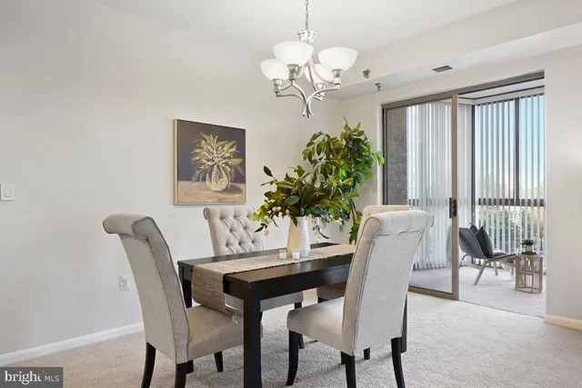 a dining room with furniture potted plants and a chandelier
